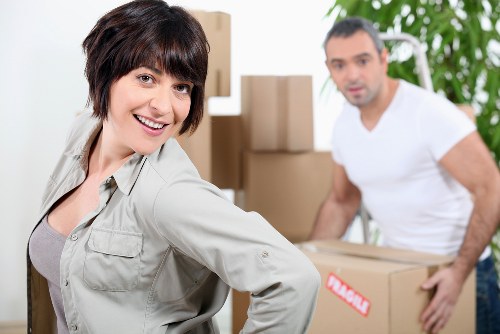 Moving crew handling furniture in a Hampstead apartment with narrow access